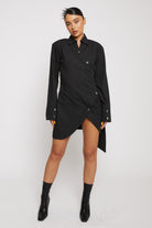Front view of a model wearing the women's black cotton asymmetric shirt dress.