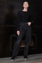 Full view of a model wearing the women's black bodysuit with jeans.