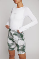 Front close-up of a woman wearing the white long-sleeve bodysuit.