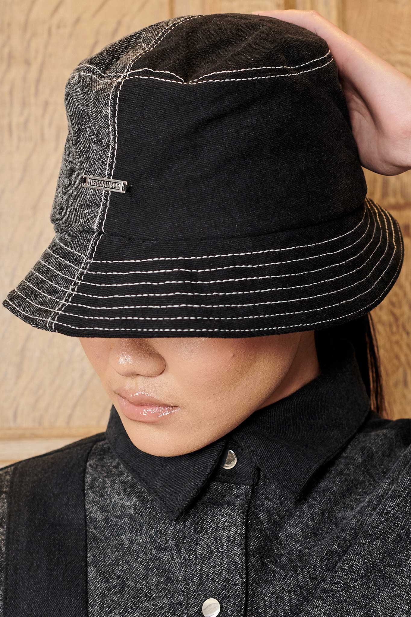 Close-up of a model wearing the women's acid wash bucket hat, showing the logo and stitching