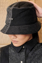 Close-up of a model wearing the women's acid wash bucket hat, showing the logo and stitching