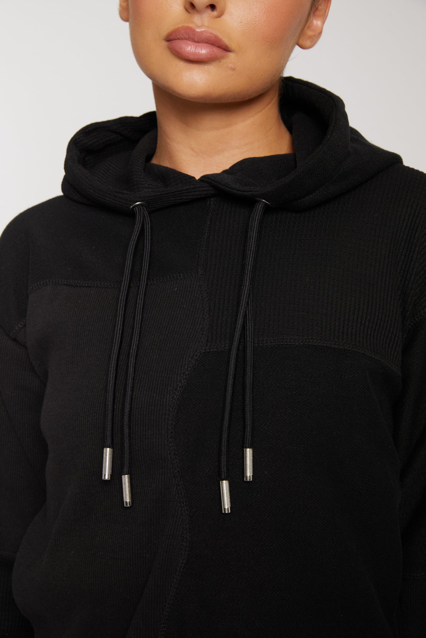 Detailed close up of the thumb hole in the sleeve on black kroen hoodie