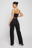 Full back view of a model in the women's black straight leg jeans.