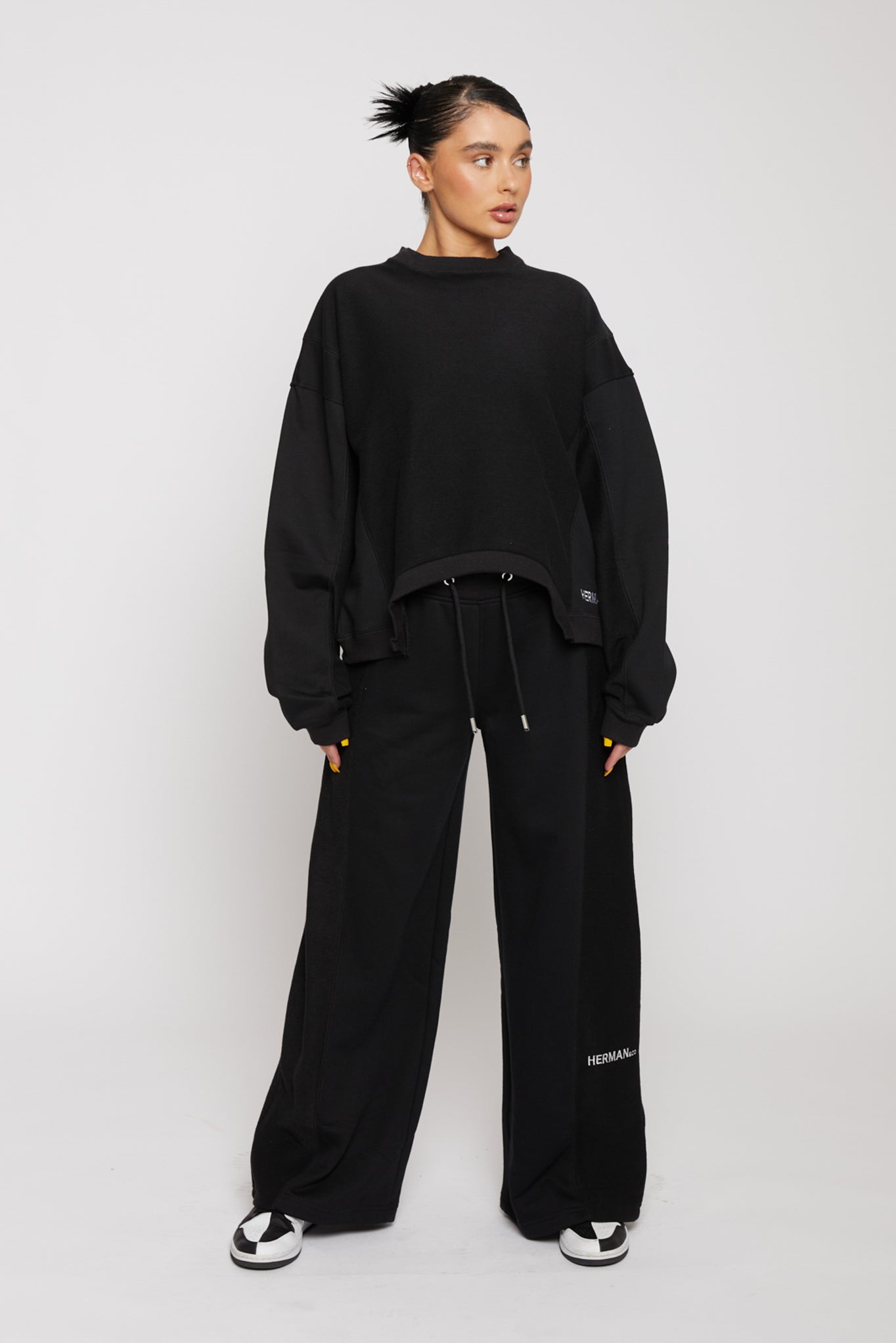 Front view of model styled in black kroen joggers womens with a matching oversized sweater