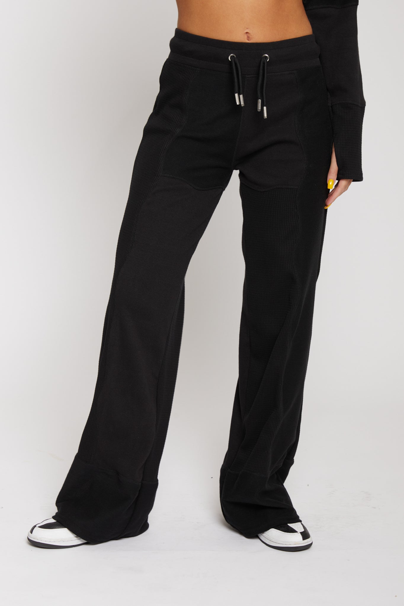 Front view of model wearing black kroen joggers with a matching hoodie