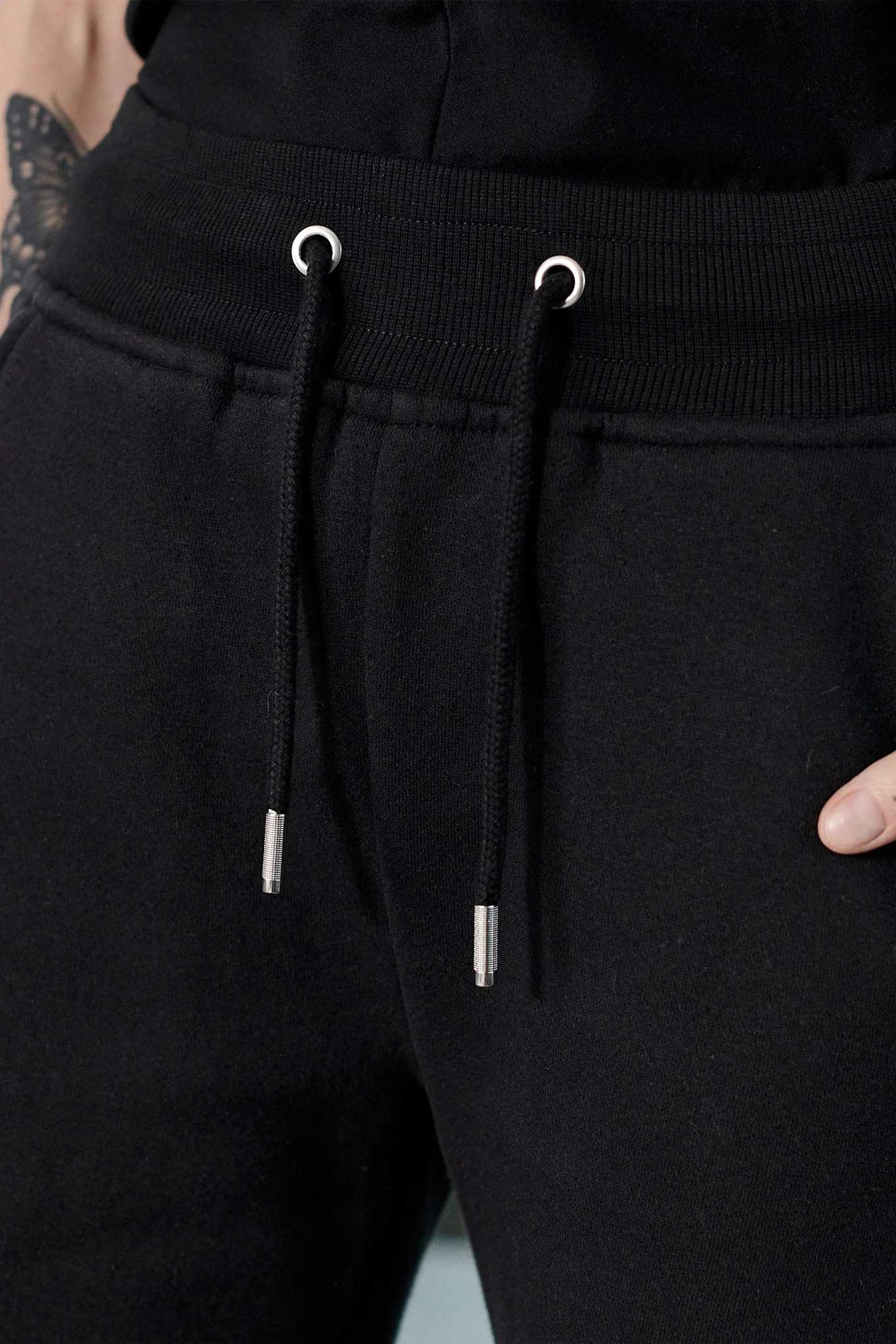Detailed view of the back pocket stitching on womens black fleece shorts