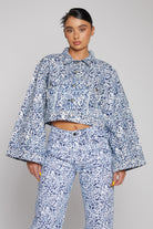Front close-up of the women's blue marble print crop denim jacket.