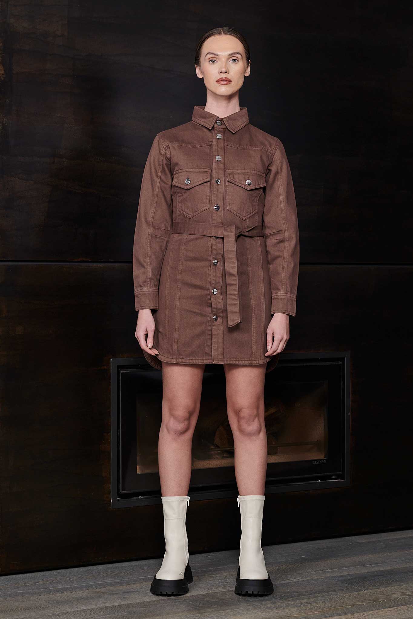 Model wearing the women's brown denim shirt dress, styled with white boots