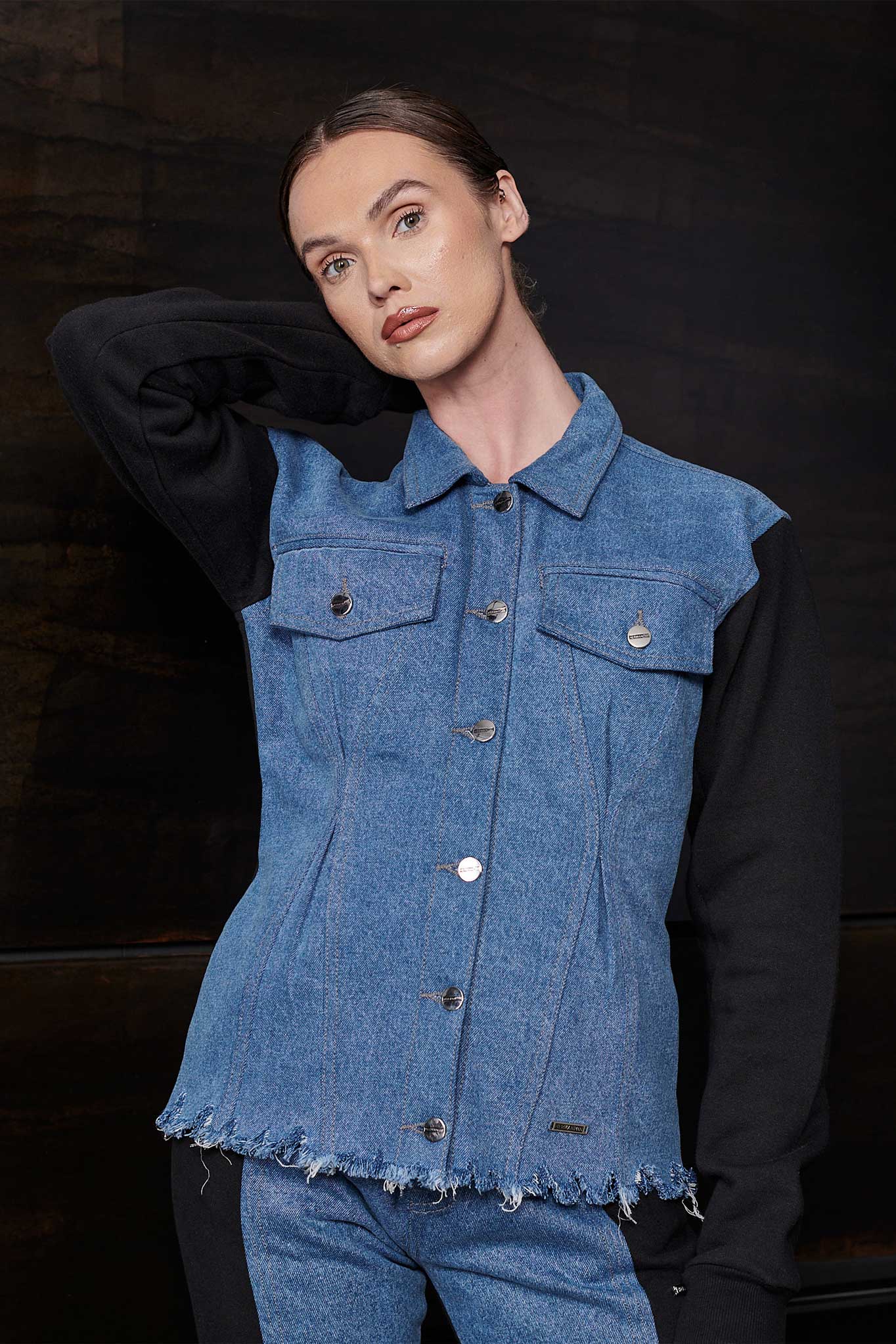 Close-up of the women's fleece jean jacket showing the denim body and frayed hem.