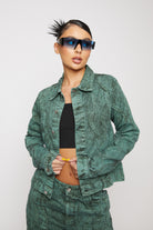 Close-up of a model wearing the women's green acid wash denim jacket.