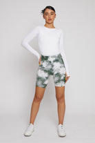 A model styled in the women's green tie-dye printed cycling shorts.