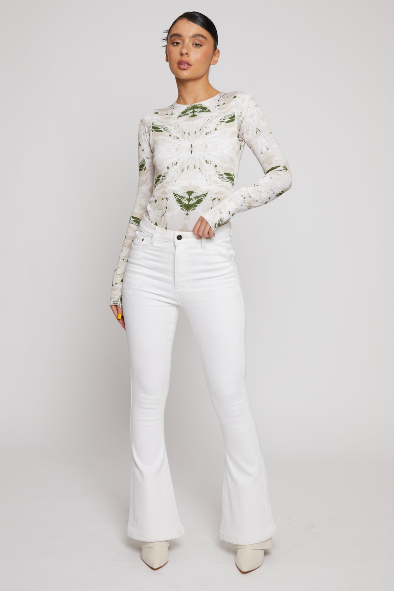 Front view of a model wearing the women's high-waisted white flare jeans.