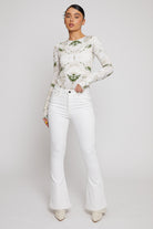 Front view of a model wearing the women's high-waisted white flare jeans.