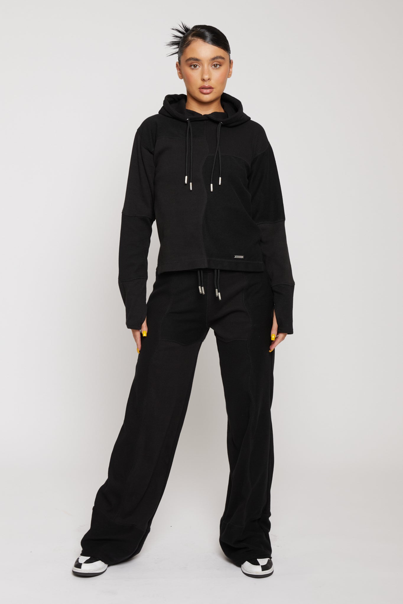 Front full body view of model wearing black drawstring hoodie women's with matching wide leg joggers