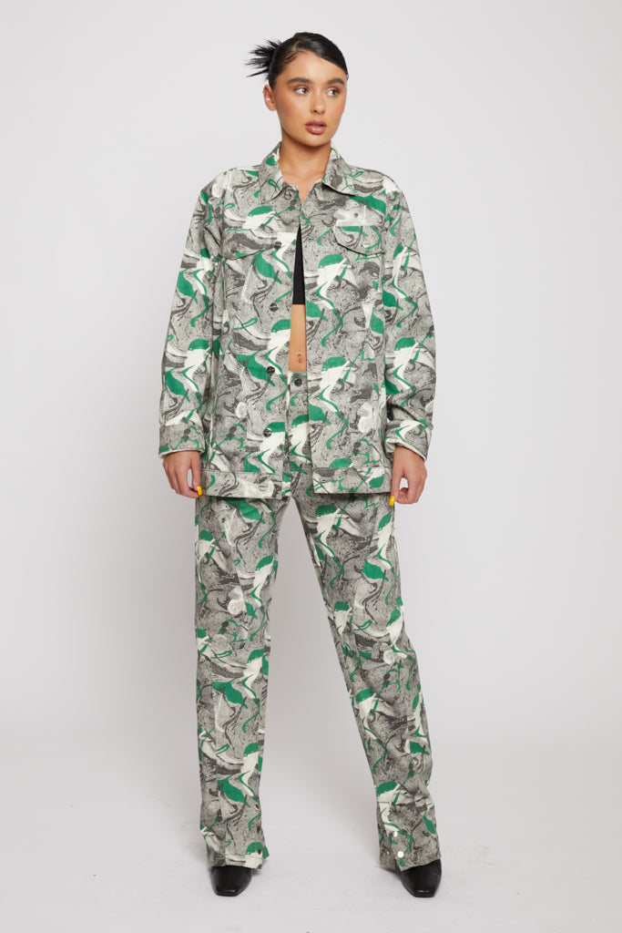 A model styled in the women's psychedelic print jeans with a matching jacket.