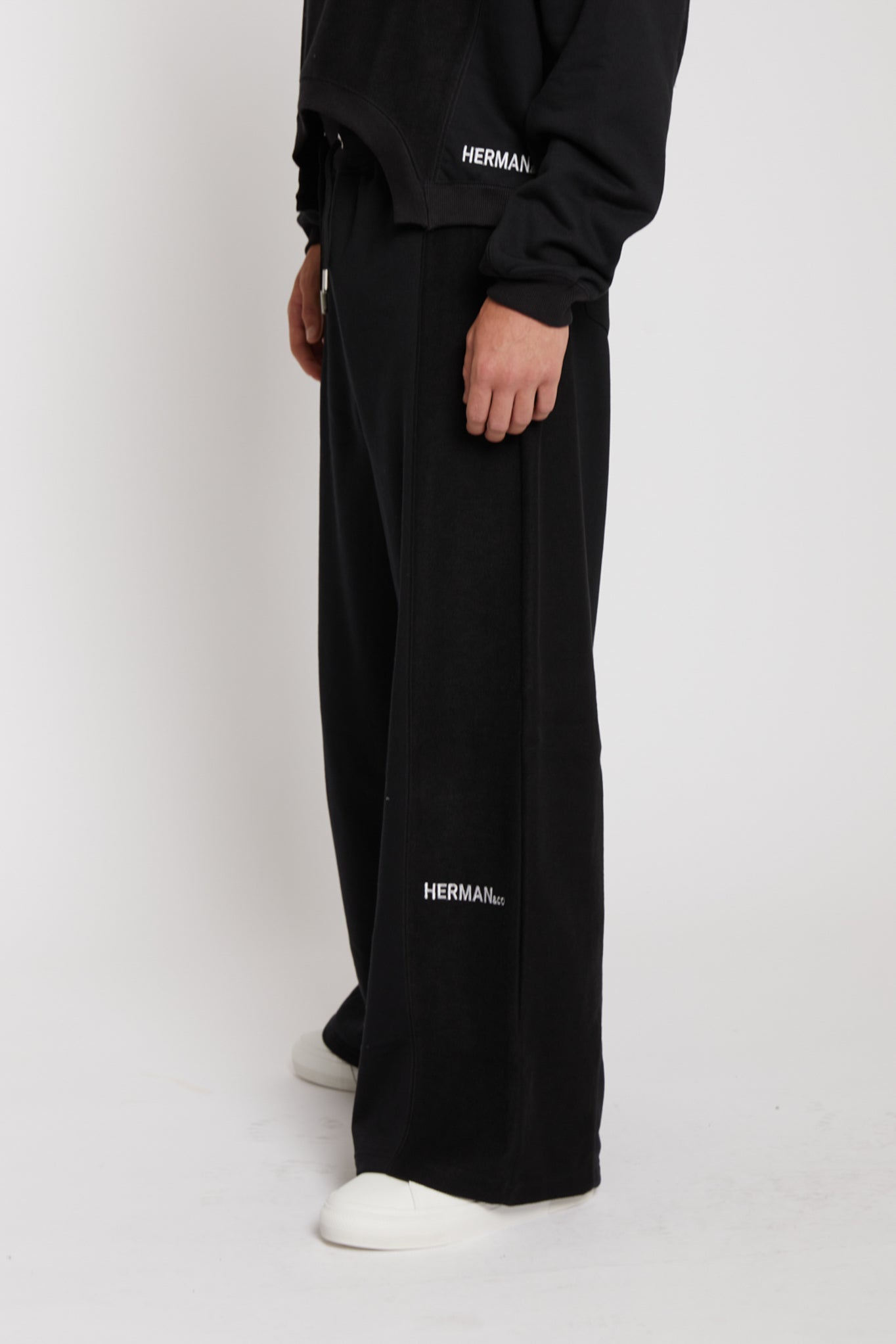 Side profile view showing the relaxed fit and mixed fabric detail on black kroen joggers