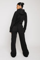 Side angle view of womens black wide leg joggers with mixed fabric detail